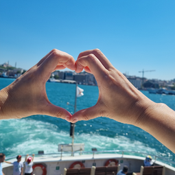 Hand Shaping a Heart on Ship Overlooking the Sea